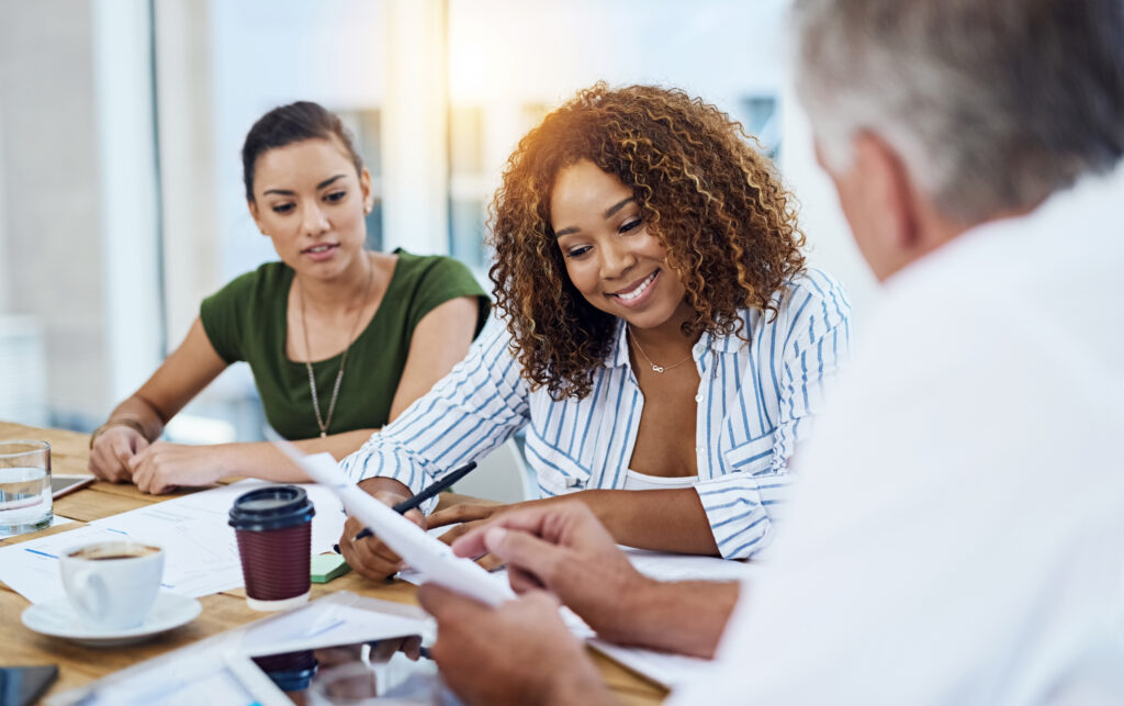 Diverse business team collaborating in a professional office, engaged in a training and development workshop.